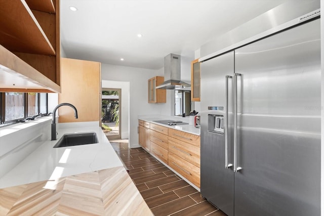 kitchen with stainless steel built in fridge, wall chimney exhaust hood, dark hardwood / wood-style floors, and plenty of natural light