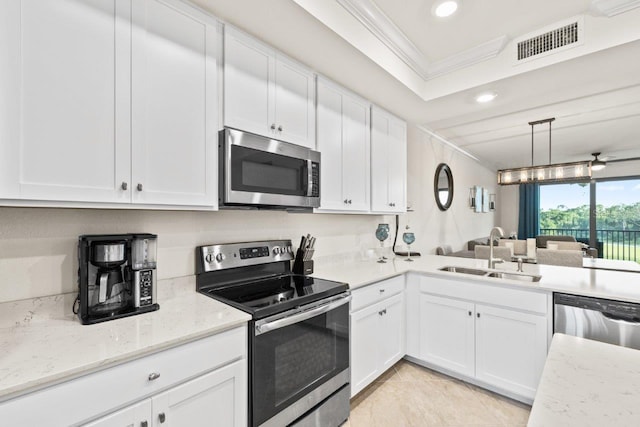 kitchen with appliances with stainless steel finishes, white cabinetry, sink, and ornamental molding