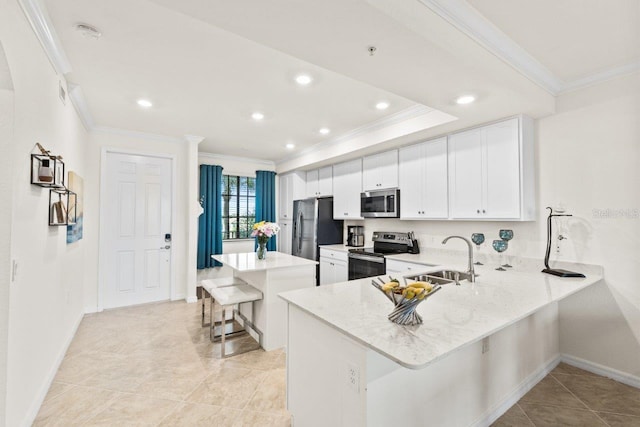 kitchen with stainless steel appliances, a breakfast bar, sink, kitchen peninsula, and white cabinetry