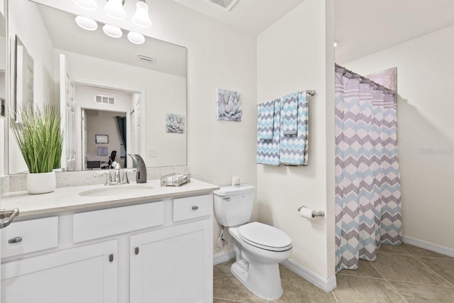 bathroom featuring vanity, tile patterned flooring, and toilet