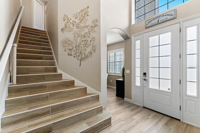 foyer entrance with light hardwood / wood-style floors and a high ceiling