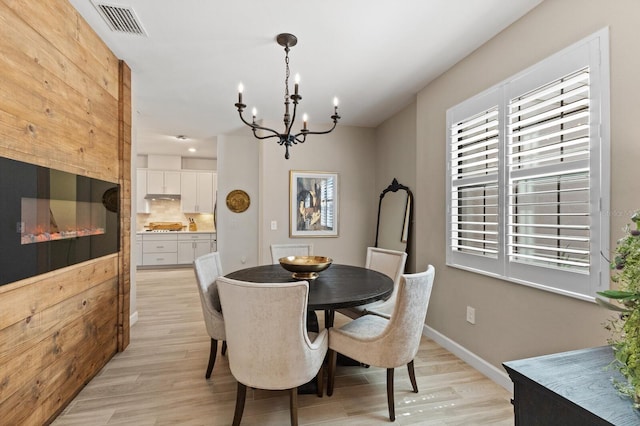 dining area featuring light hardwood / wood-style flooring and a chandelier