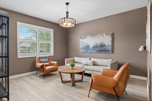 living room with a notable chandelier and light hardwood / wood-style flooring