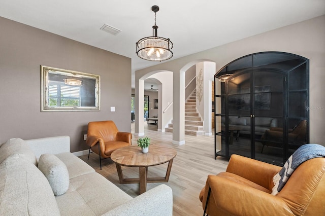 living room with an inviting chandelier and light wood-type flooring