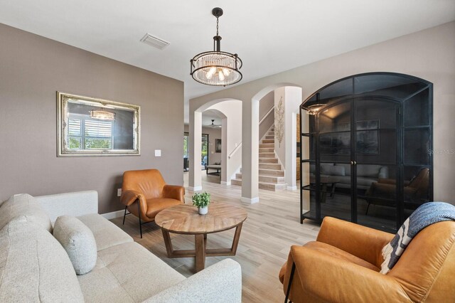 16215 Tradewind Ter, Lakewood Ranch, FL 34211 - living room with arched walkways, baseboards, healthy amount of natural light, and light wood-style floors