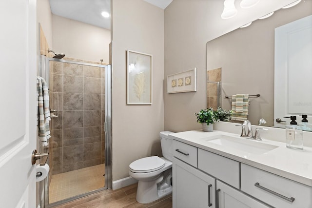 bathroom with vanity, hardwood / wood-style floors, toilet, and an enclosed shower