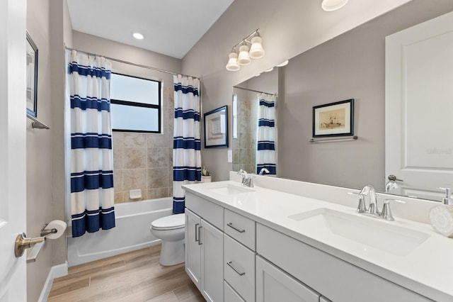 full bathroom featuring toilet, hardwood / wood-style flooring, shower / bath combination with curtain, and vanity