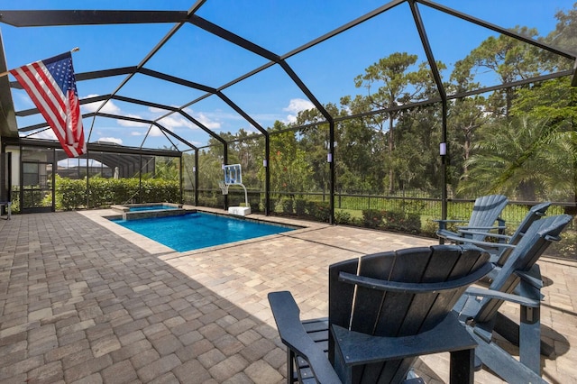 view of pool with a patio, a lanai, and an in ground hot tub