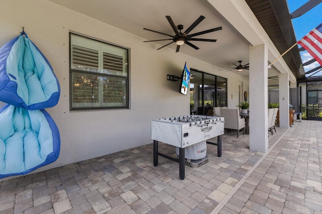 view of patio / terrace with ceiling fan and a lanai