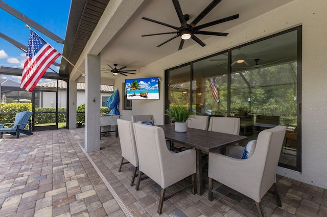 view of patio / terrace featuring ceiling fan and glass enclosure