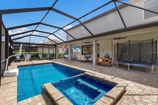 view of swimming pool featuring a patio area, a lanai, an in ground hot tub, and ceiling fan