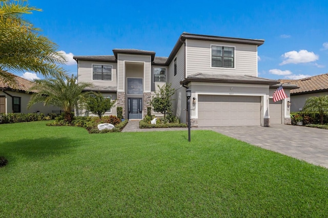16215 Tradewind Ter, Lakewood Ranch, FL 34211 - view of front of home with an attached garage, stone siding, a front yard, and driveway
