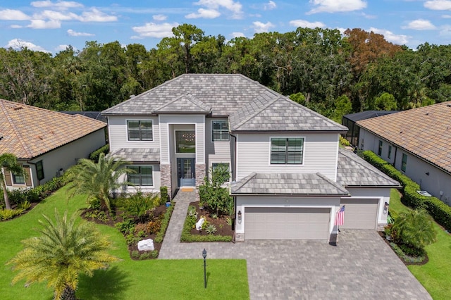 16215 Tradewind Ter, Lakewood Ranch, FL 34211 - view of front of home with a front yard, driveway, stone siding, and an attached garage