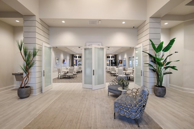 interior space featuring light hardwood / wood-style floors and a high ceiling