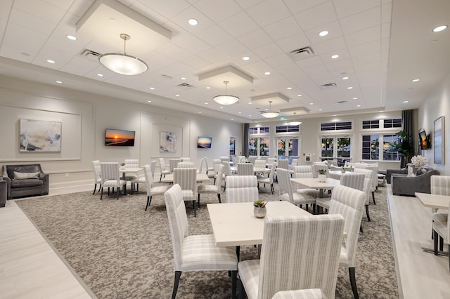 dining space featuring a tray ceiling and light hardwood / wood-style flooring