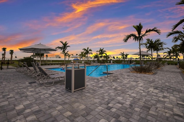 16215 Tradewind Ter, Lakewood Ranch, FL 34211 - pool at dusk with fence, a community pool, and a patio area