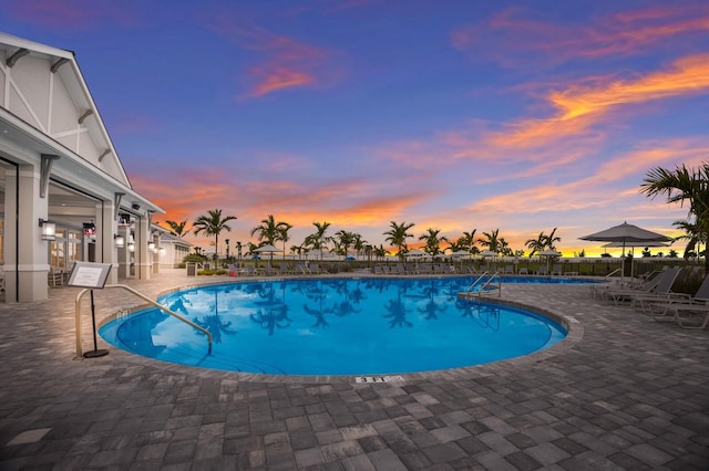 pool at dusk with a patio area