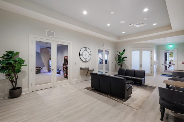 16215 Tradewind Ter, Lakewood Ranch, FL 34211 - living area featuring french doors, light wood finished floors, recessed lighting, a raised ceiling, and baseboards