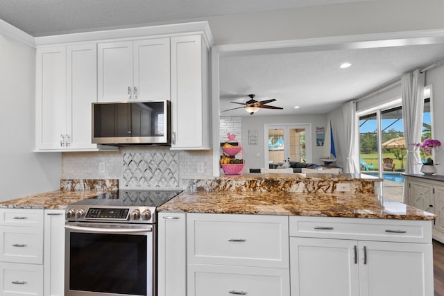 kitchen featuring appliances with stainless steel finishes, dark wood-type flooring, white cabinets, light stone countertops, and ceiling fan