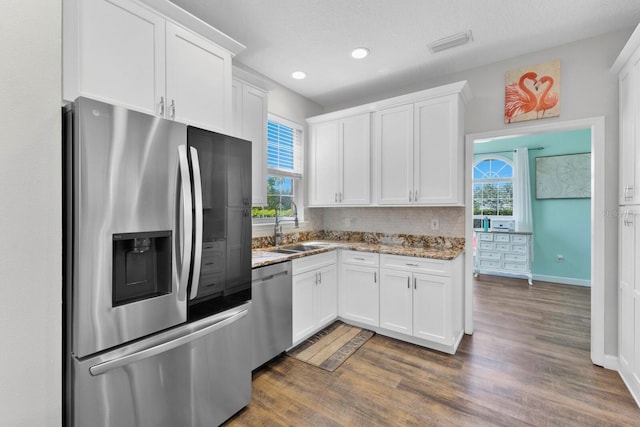 kitchen with appliances with stainless steel finishes, white cabinetry, and plenty of natural light