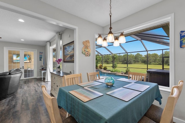 dining room featuring a textured ceiling, a healthy amount of sunlight, and dark hardwood / wood-style flooring