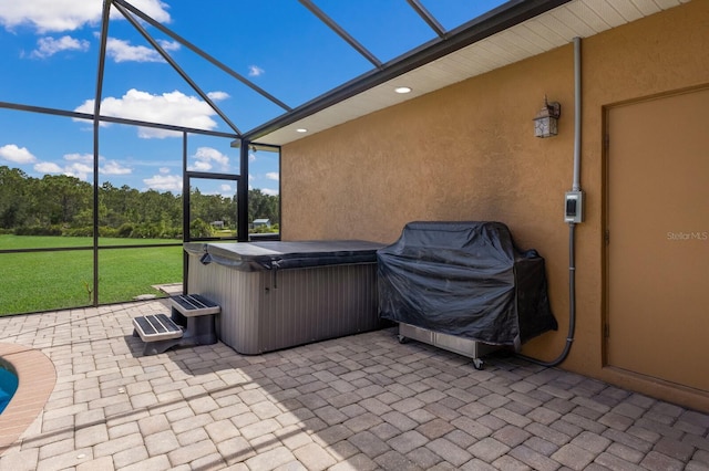 view of patio / terrace with area for grilling, glass enclosure, and a hot tub