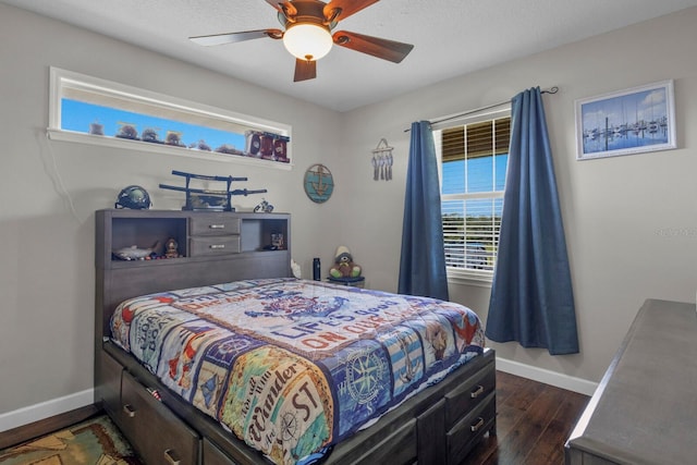 bedroom with a textured ceiling, ceiling fan, and dark hardwood / wood-style flooring