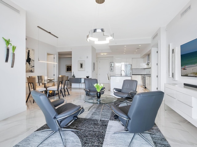 living room with a chandelier, visible vents, and marble finish floor