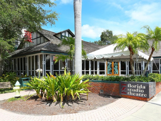 rear view of property featuring a sunroom