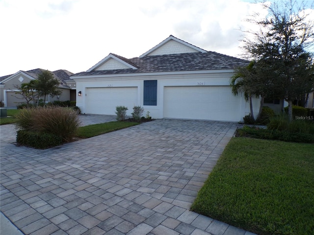 ranch-style house with a garage and a front lawn