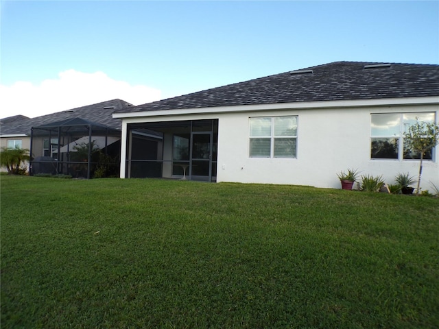 rear view of property featuring a yard and a sunroom