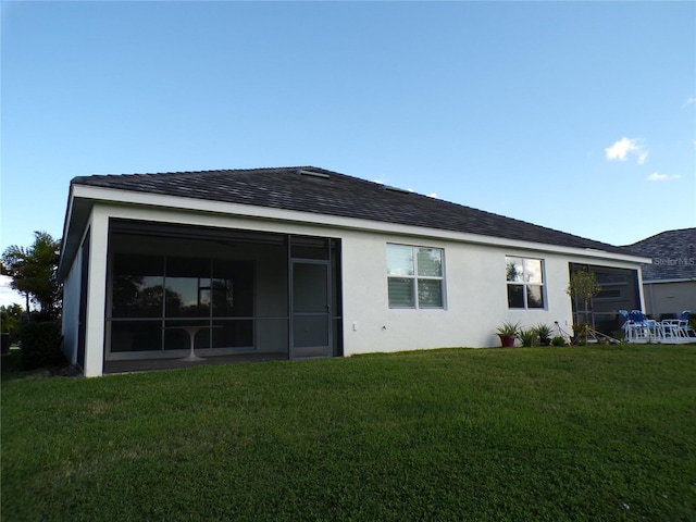 rear view of property featuring a yard and a sunroom