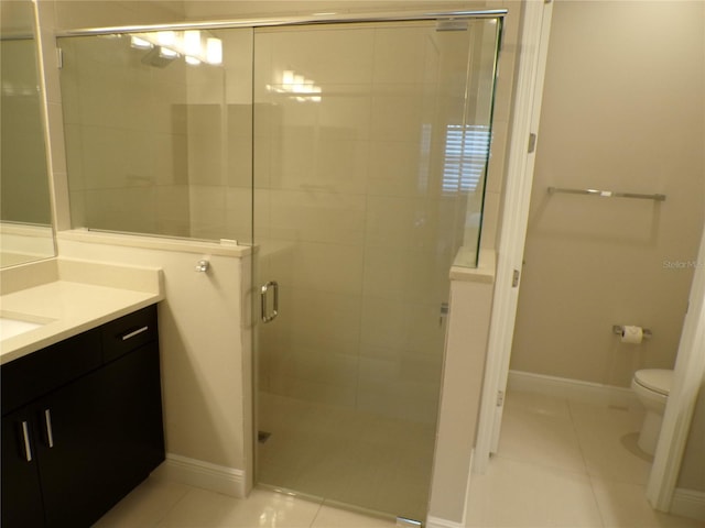 bathroom with vanity, tile patterned floors, toilet, and an enclosed shower