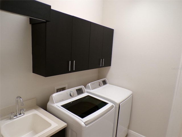 laundry room featuring sink, washing machine and clothes dryer, and cabinets