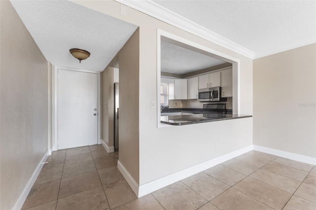 kitchen with white cabinetry, a textured ceiling, and light tile patterned flooring