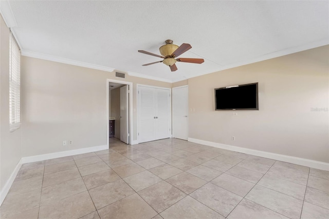 tiled empty room featuring crown molding, a textured ceiling, and ceiling fan