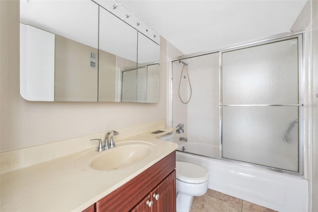 full bathroom featuring vanity, toilet, shower / bath combination with glass door, and tile patterned flooring