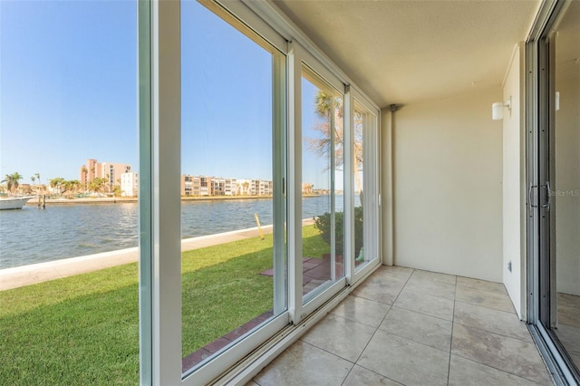 unfurnished sunroom featuring a water view and plenty of natural light