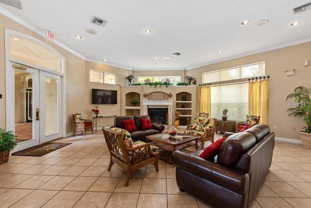 living room with light tile patterned floors, french doors, and crown molding