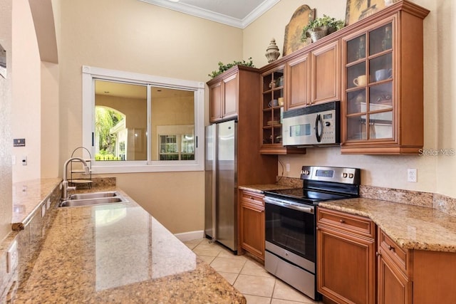 kitchen featuring stainless steel appliances, light stone counters, crown molding, and sink