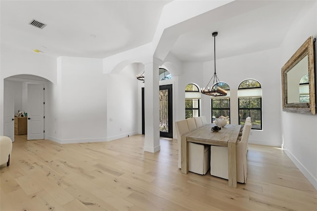 dining room with light hardwood / wood-style floors and a chandelier