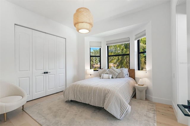 bedroom with light hardwood / wood-style flooring and a closet