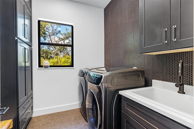 laundry room featuring cabinets, light tile patterned floors, washer and clothes dryer, and sink