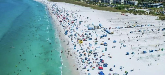 birds eye view of property with a water view and a beach view