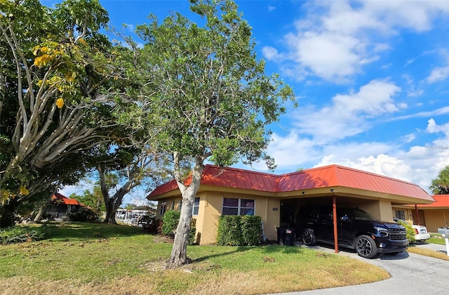 view of front of property featuring a front yard and a carport