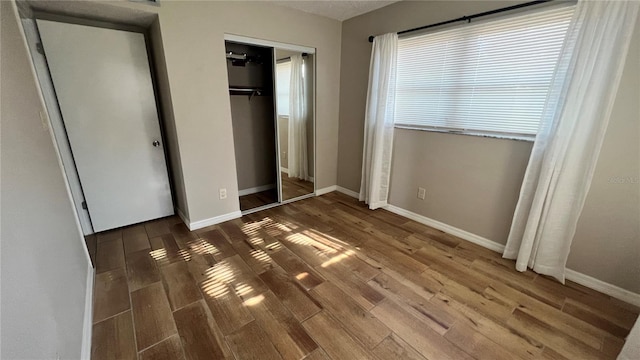 unfurnished bedroom featuring a closet and dark hardwood / wood-style flooring