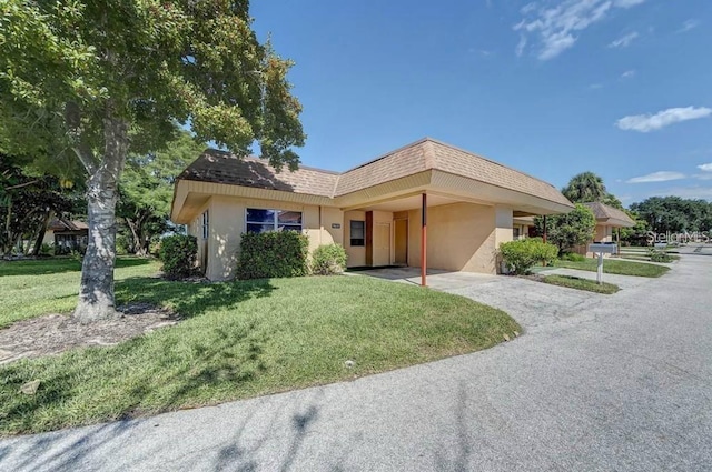 view of front of house with a front yard and a carport