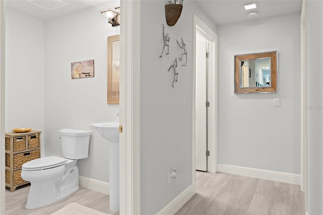 bathroom featuring hardwood / wood-style floors and toilet