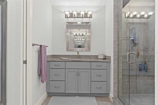 bathroom featuring tile patterned flooring, vanity, and a shower with shower door