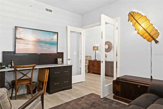 office area with french doors and light hardwood / wood-style flooring